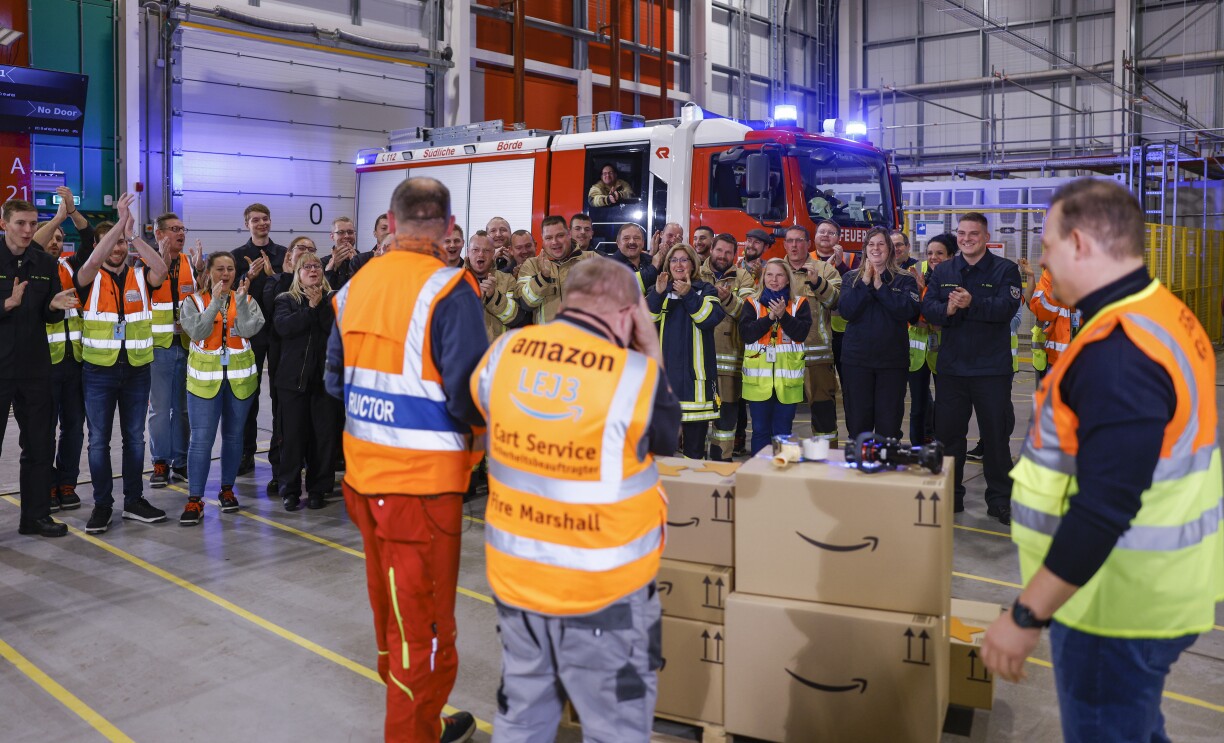 Alex und Uwe werden im Amazon Logistikzentrum Sülzetal von Kolleginnen und Kollegen sowie von ihren Kameraden der frewilligen Feuerwehr mit der Amazon Star Auszeichnung überrascht.
