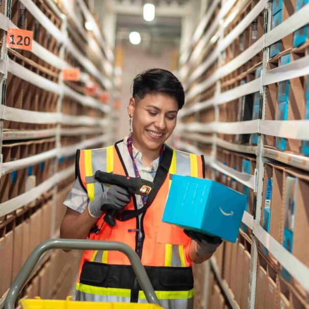 Trabajdora de un centro logístico de Amazon escaneando un producto. 