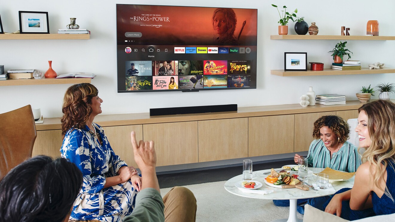 Gruppe von Menschen schaut gemeinsam Inhalte über Amazon Fire TV im Wohnzimmer.