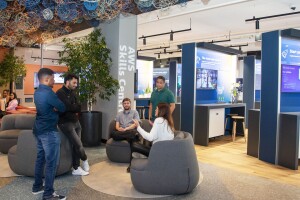 group of adults sitting in chairs and standing around a circle inside the new aws skills center in cape town south africa 