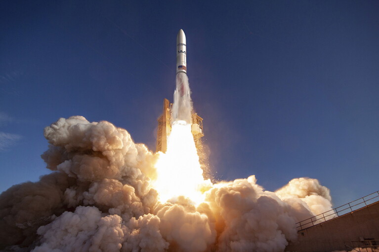An image showing a rocket launching from its base. There is fire and smoke coming from the bottom of the rocket to propel it.