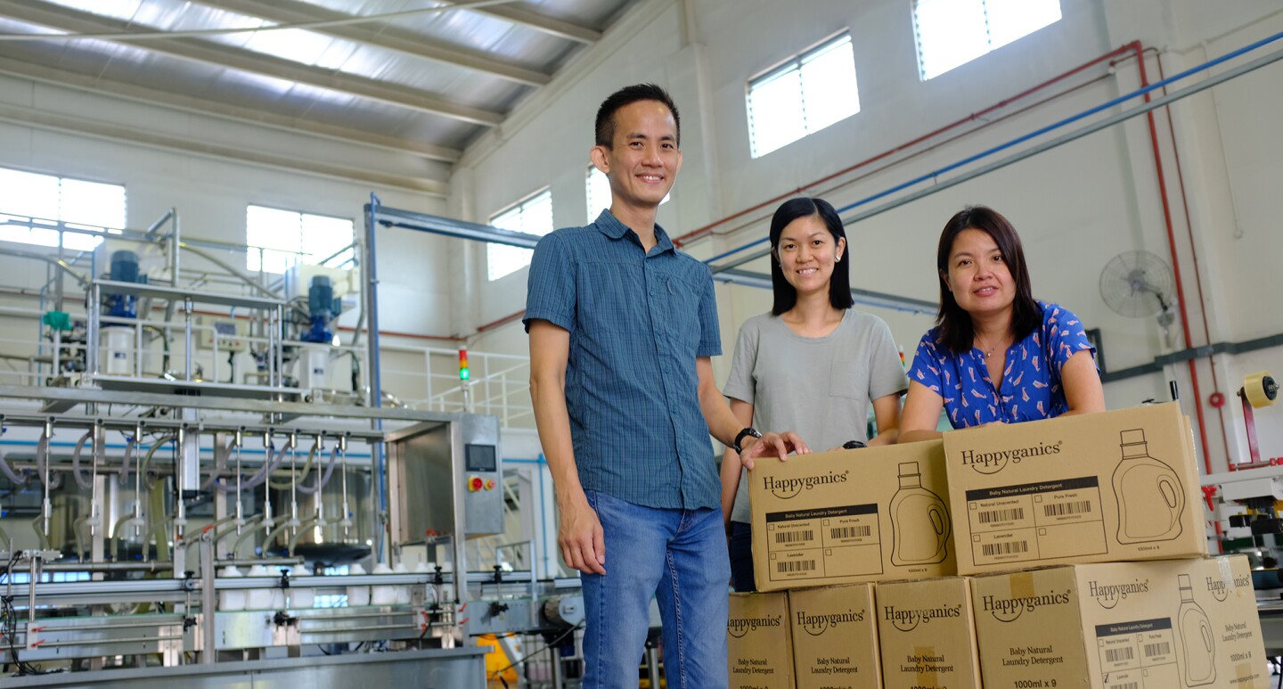 The team behind Happyganics, with their products in a factory