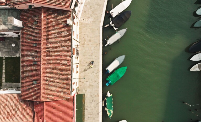 Photos of an aerial view of the Lagoon and an Amazon delivery driver handing over a delivery to a customer at his doorstep.