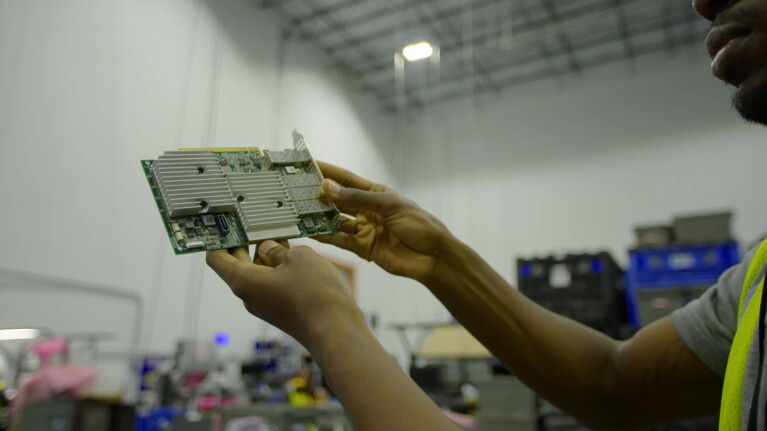 A photo of a person holding a piece of a decommissioned AWS data center server rack. 