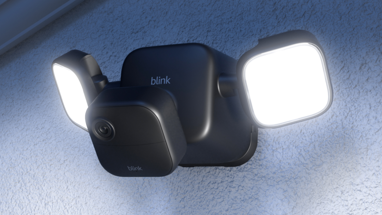 Blink Floodlight Cam mounted on a white wall, with two, bright, LED lights and a camera attached to the front