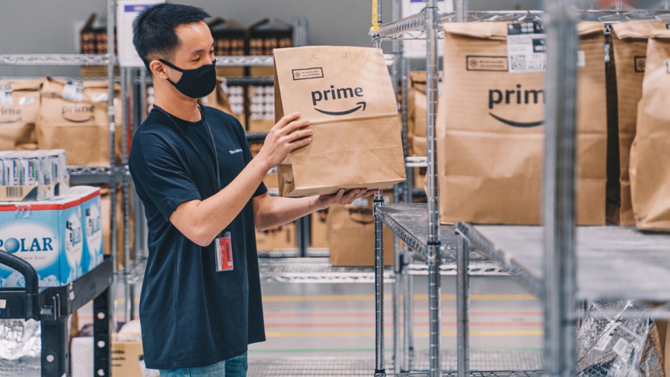 An employee placing orders onto shelves, ready for pick up by delivery drivers