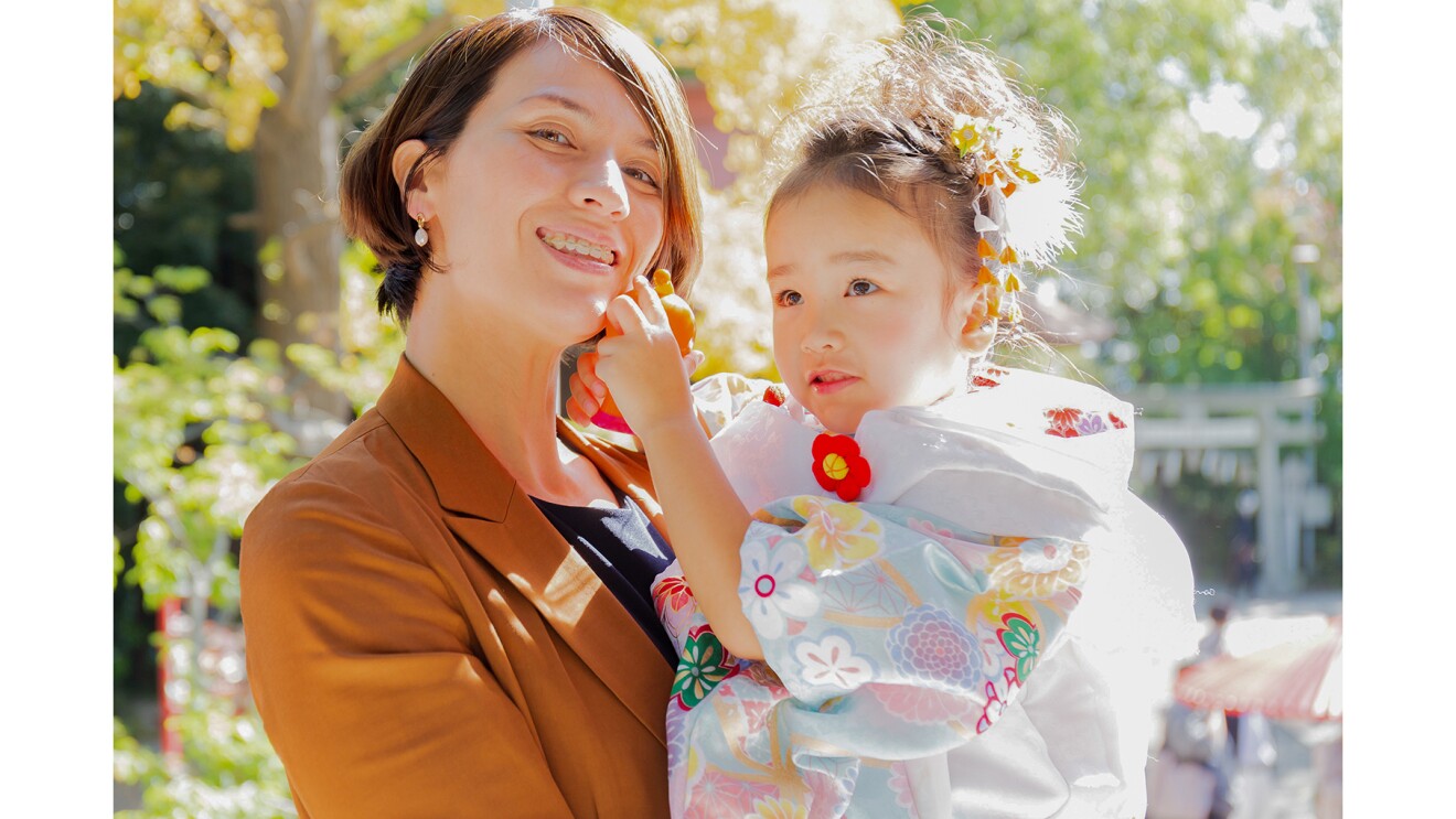 晴れ着を着たお子さんを抱き、笑顔の越知さんの写真