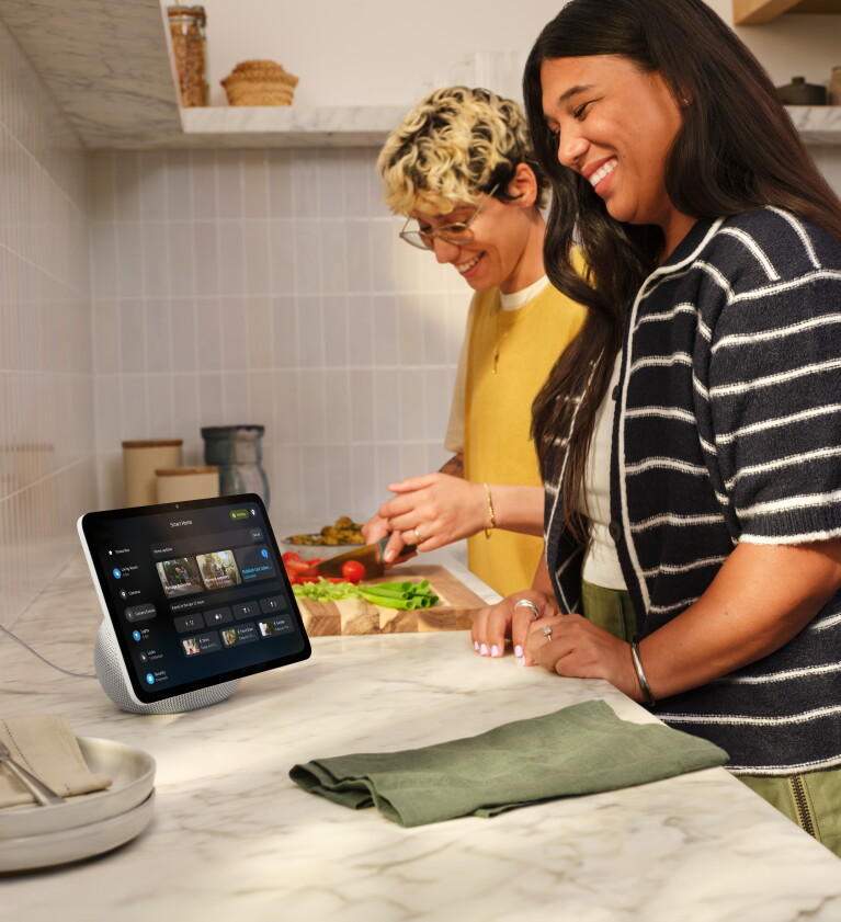 Two people smiling in the kitchen while using their Echo Show