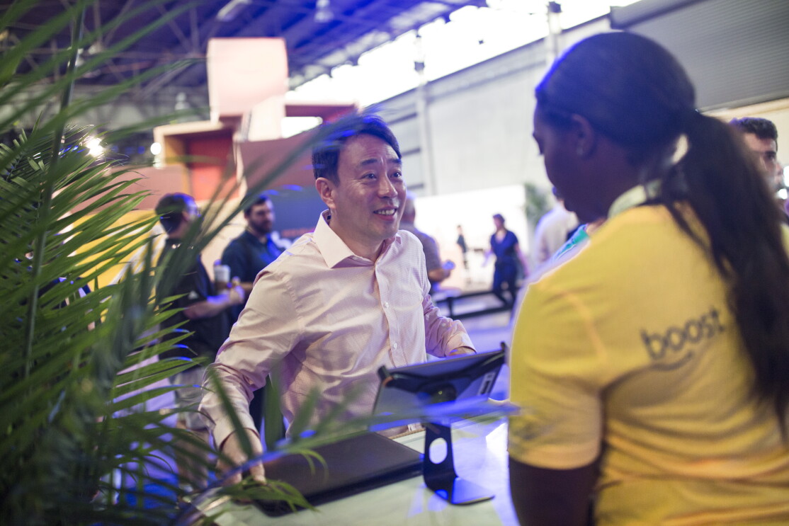 Small business owner talking to an Amazon associate at the Amazon Boost FBA conference. The Amazon employee is wearing a yellow t-shirt with "Boost" written on it. 