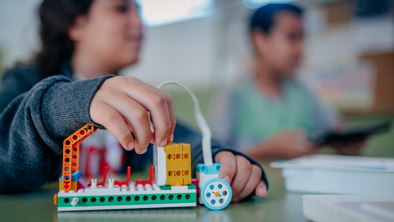 Robot creado con Legos Education Spike Essential. Tiene dos ojos con dos patas y unas palancas como si fuera un toro. 