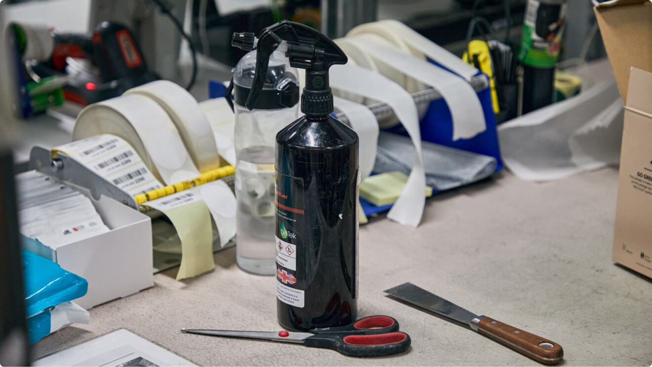 Cluttered workspace with spray bottle, scissors, and various tools