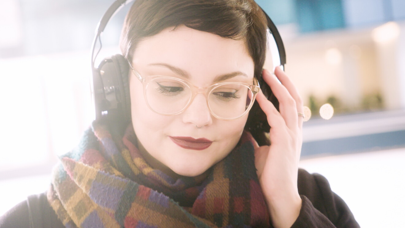 Ritratto di Giulia Massari, Marketing Manager Audible, mentre indossa delle cuffie e ascolta della musica. 
