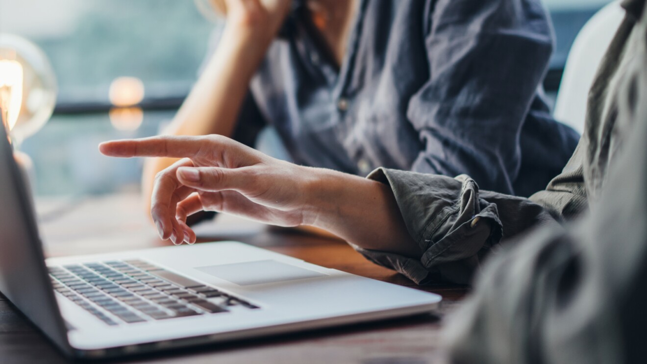 Two men in discussion next to a laptop