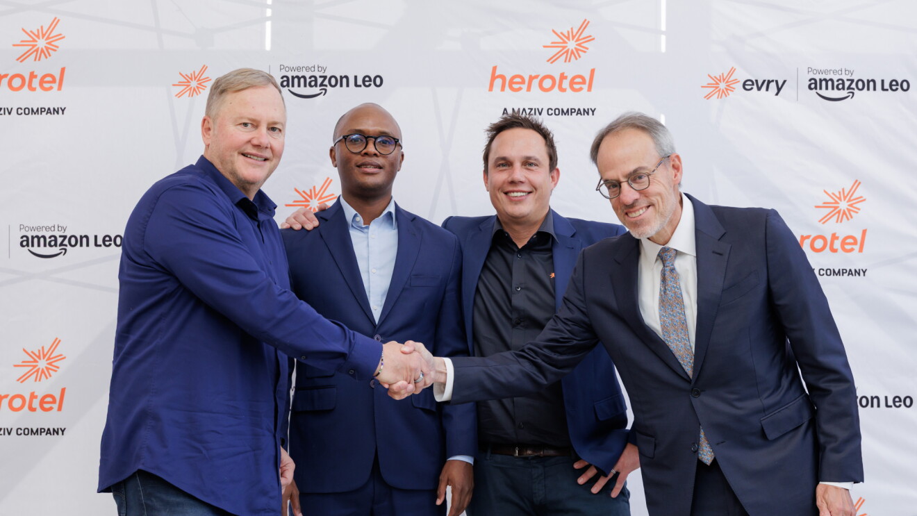 Amazon and Herotel business executives shaking hands at Herotel and Evry partnership announcement with Amazon Leo branding