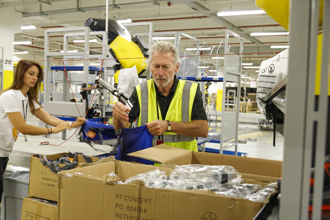 Ex-Fußballprofi Paul Breitner packte im Amazon Logistikzentrum Graben mit an für benachteiligte Schüler.jpg