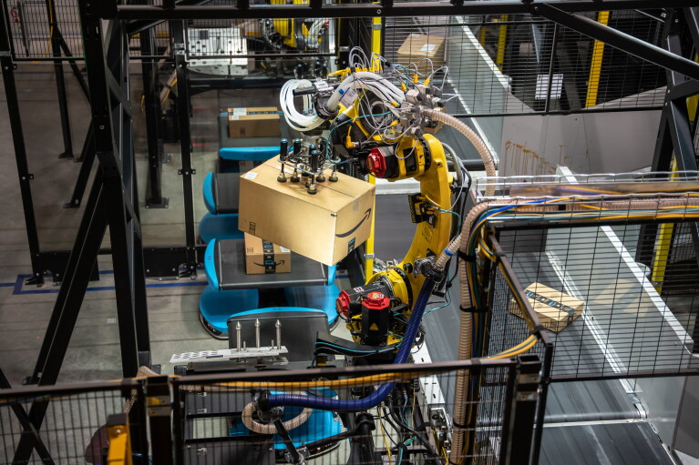 A robotic arm in an Amazon fulfillment center helps sort packages for delivery. 