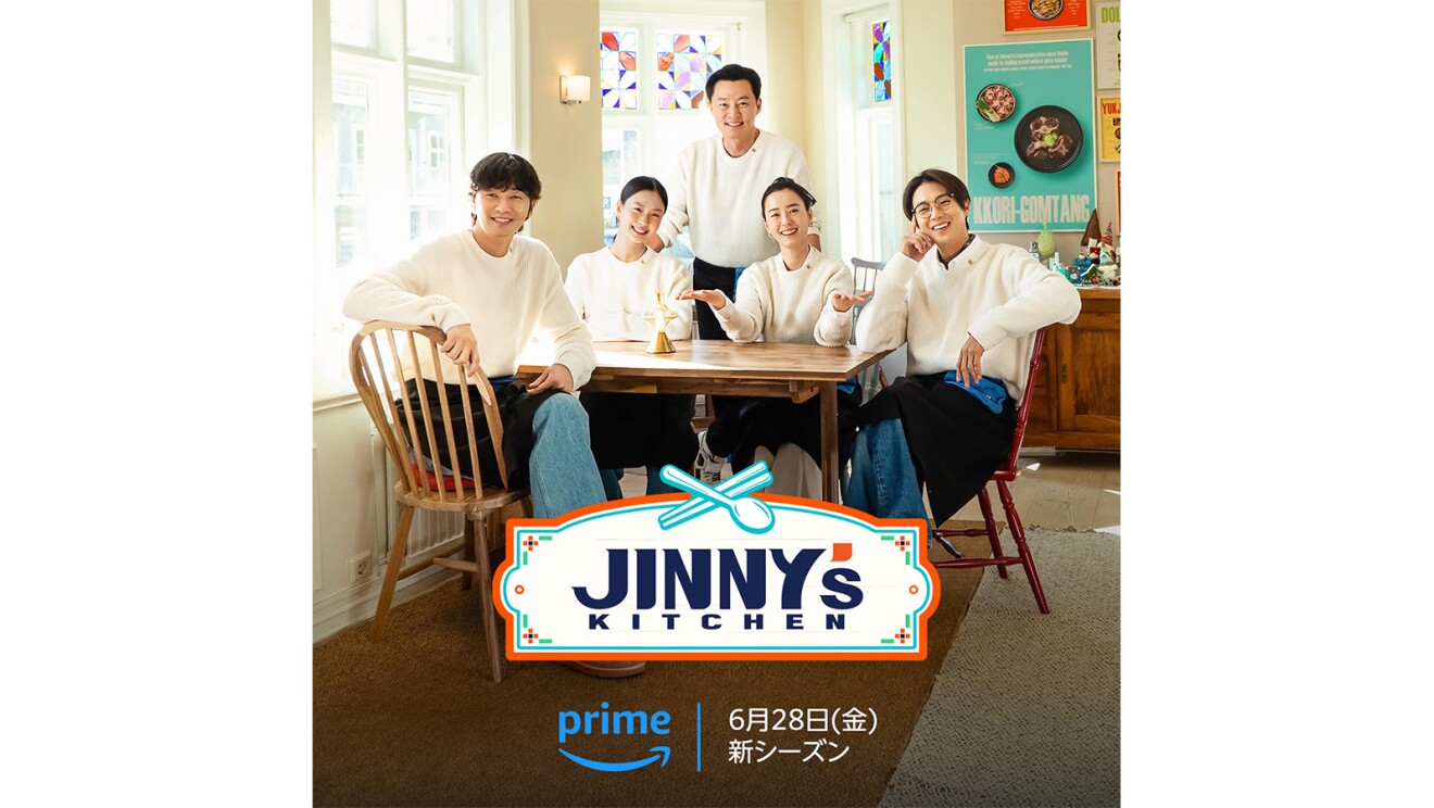 白い服を着ている男性3人と女性2人が部屋の角に置かれたテーブルの周りに座っている