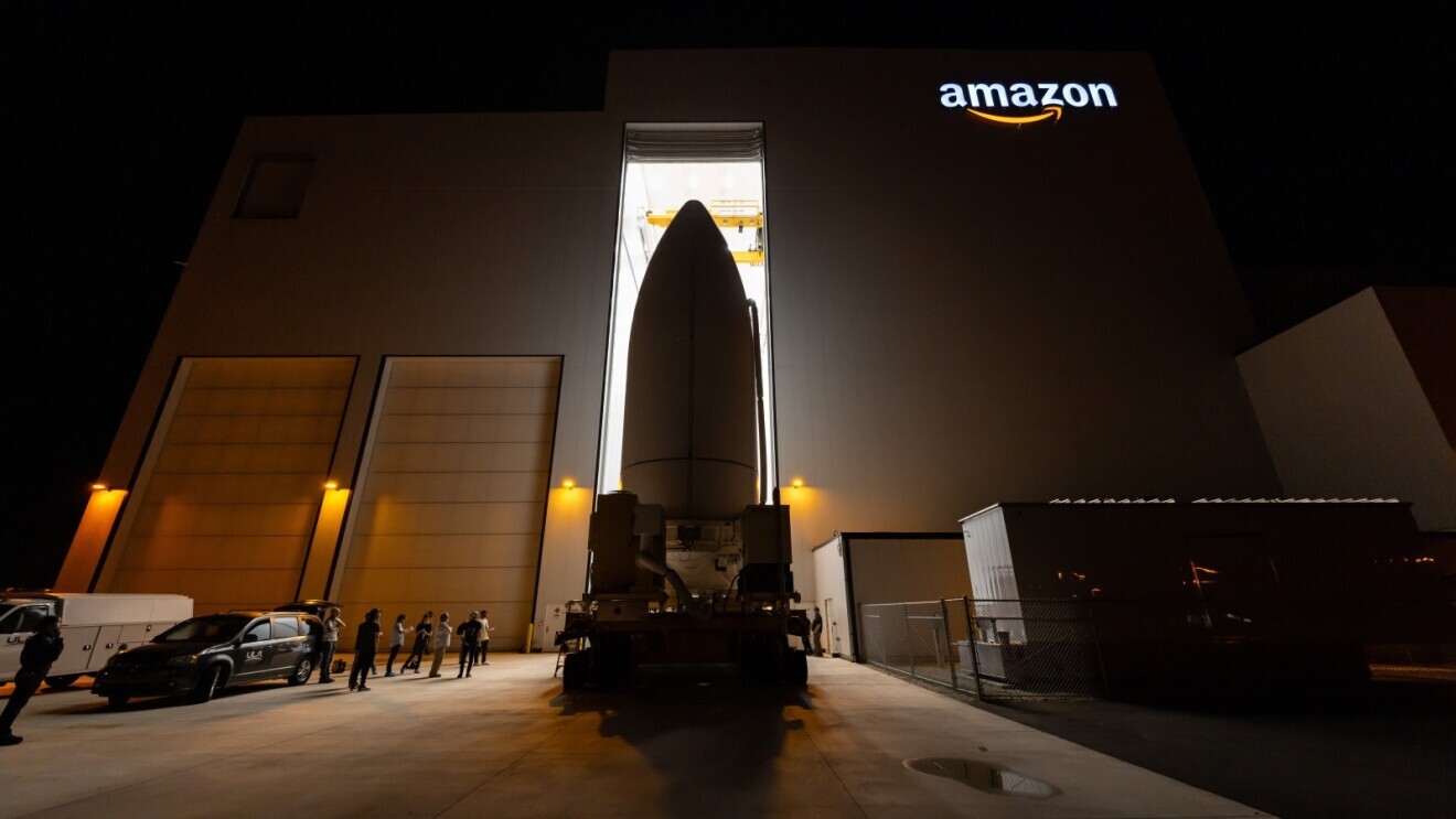 Large spacecraft in front of Amazon building with glowing logo