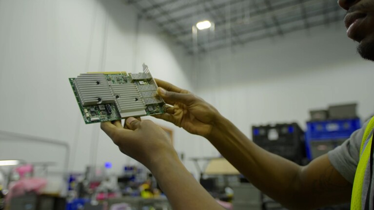 A photo of a person holding a piece of a decommissioned AWS data center server rack.