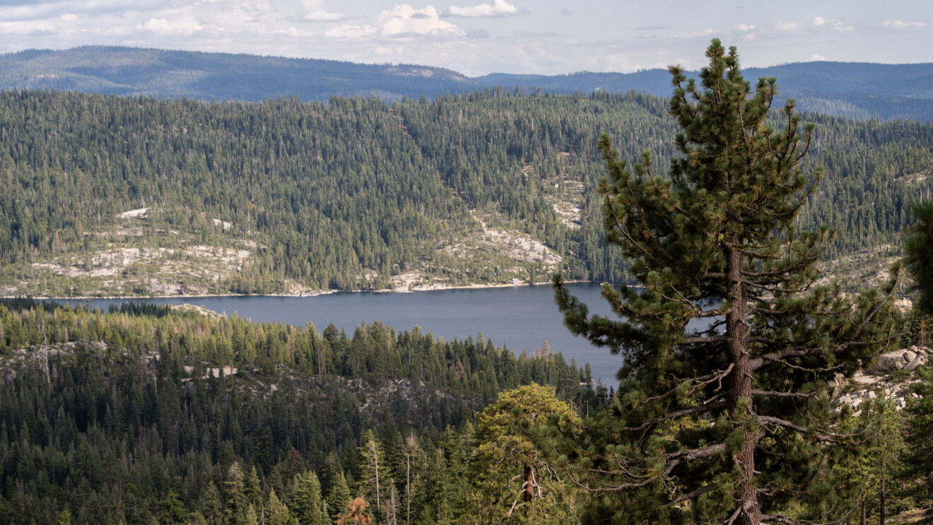Forested mountains surrounding a calm lake viewed from an elevated vantage point