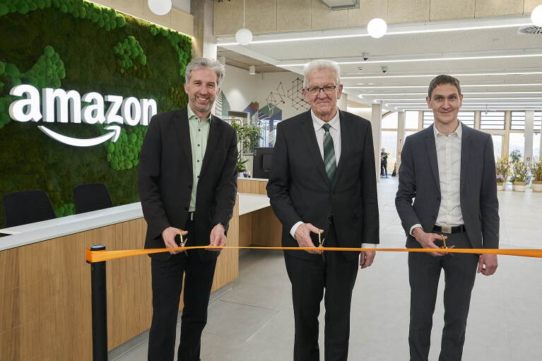 Während der Eröffnungsfeier des neuen Amazon Standorts in Tübingen zerschneiden Boris Palmer, Winfried Kretschmann und Michael Hirsch ein Band.