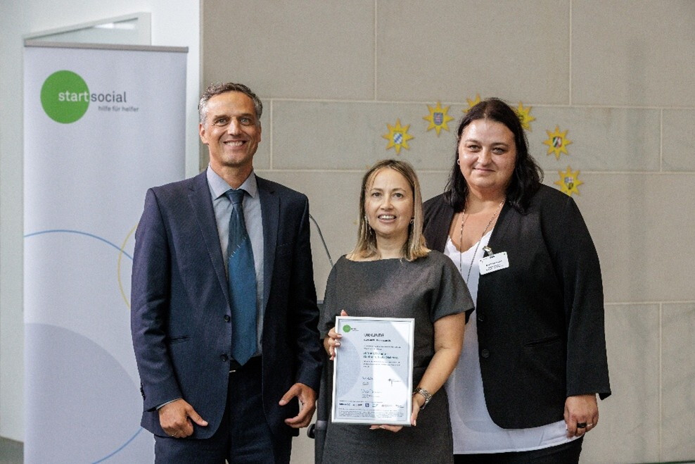 Amazon Deutschland Country Manager Rocco Bräuniger neben den Hauptpreisträgerinnen von der "Stiftung Dianiño". 