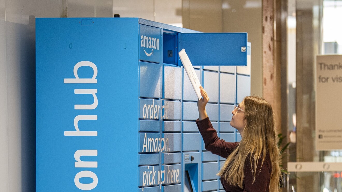 A woman is picking up envelope sized package from Amazon Locker