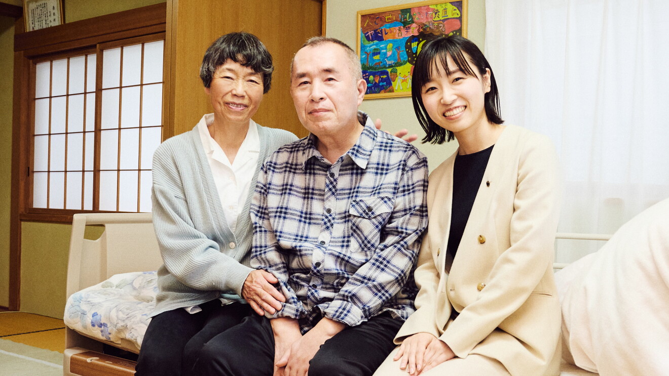手をだらんと下げているALS患者の男性。その横に女性二人が座っている