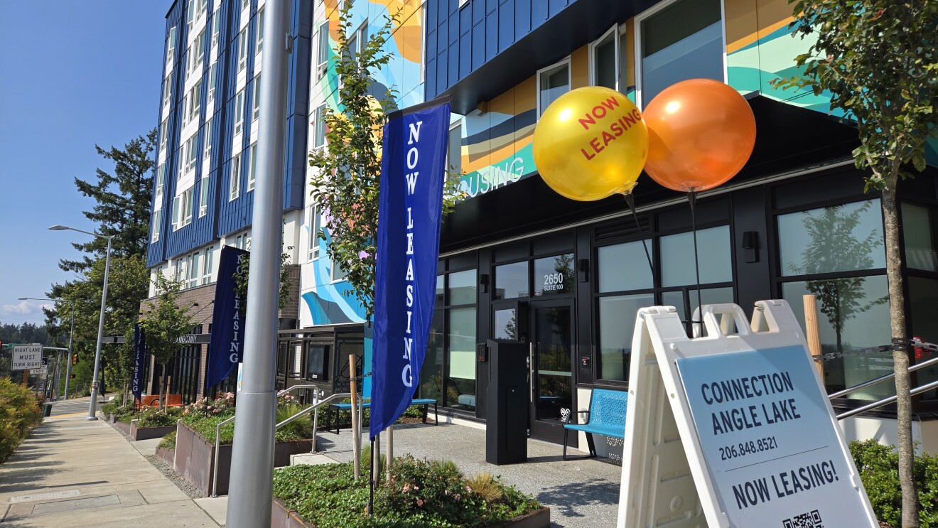 Sidewalk view of Connection Angle Lake apartments with leasing promotions