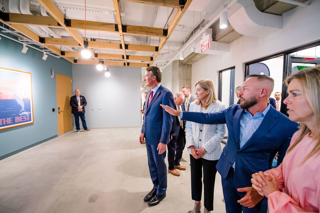 An image of a group of people looking at wall art at Amazon's second headquarters
