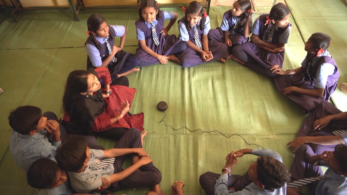 Kids sit around an Echo device
