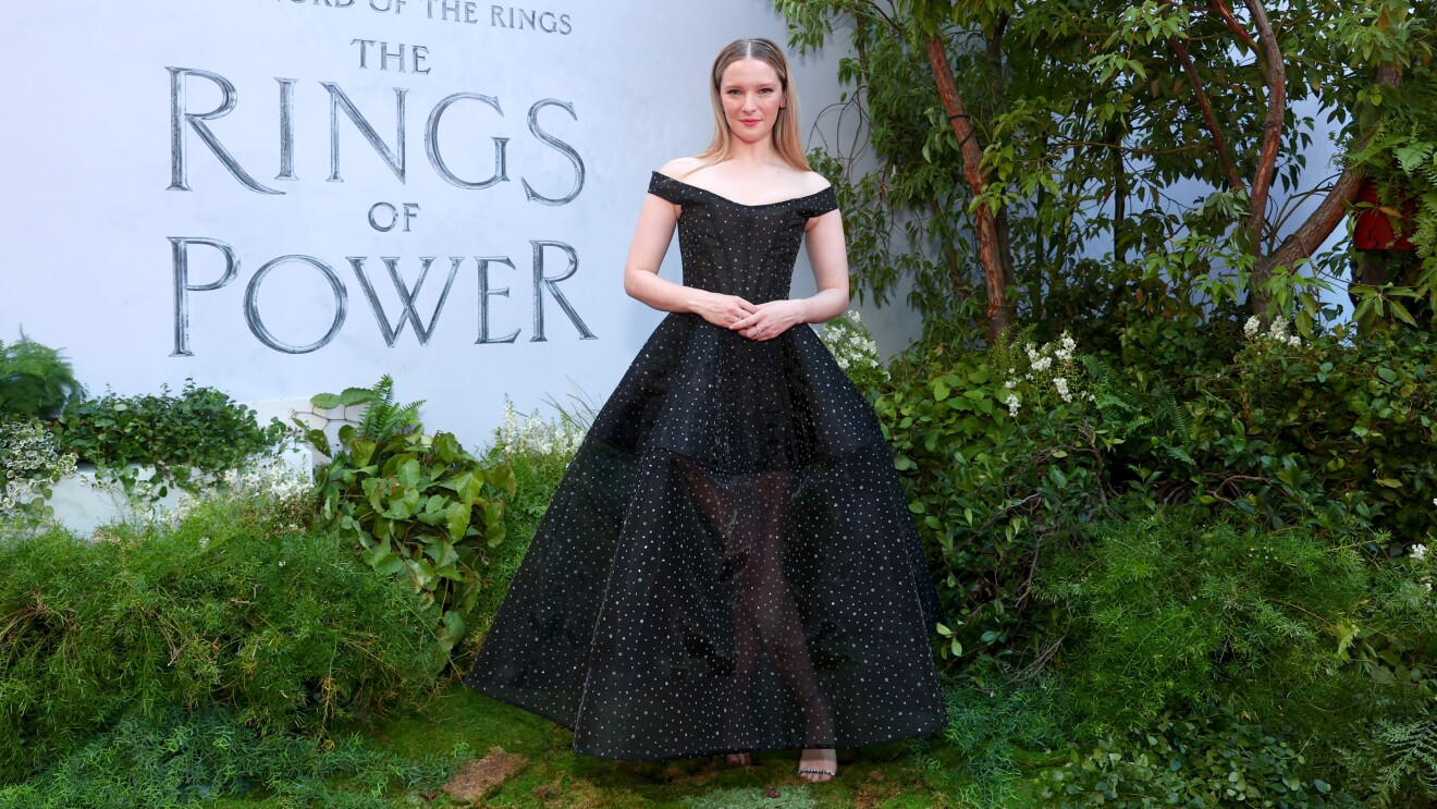 A woman smiles for a photo on the red carpet of the Lord of the Rings the Rings of Power premiere