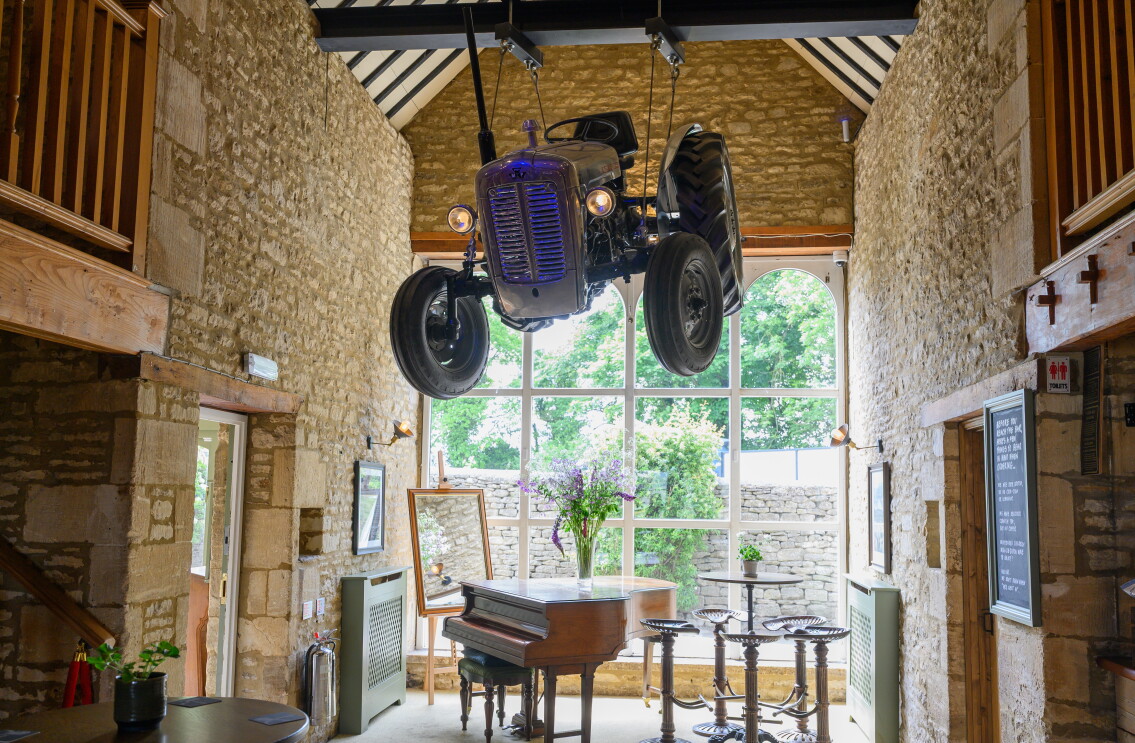 The entrance inside The Farmer's Dog in Burford, Jeremy Clarkson's proper British pub from Clarkson's Farm season 4, which sees a tractor hanging over a piano