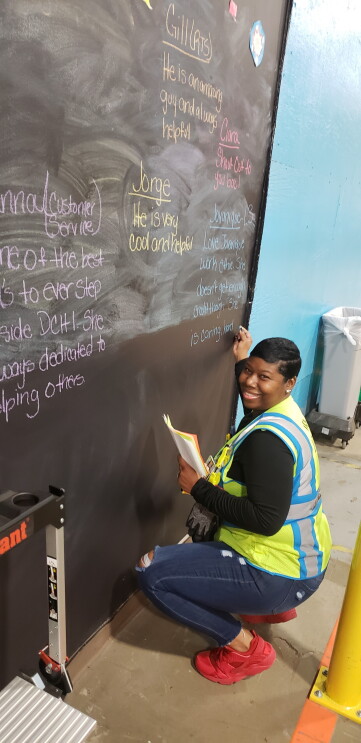 Amazon associate Tonisha Williams writes on a chalk board at an Amazon fulfillment center.