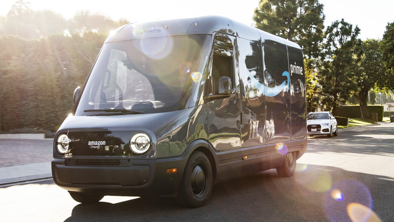 An Amazon-branded Rivian electric vehicle drives in a Los Angeles neighborhood.