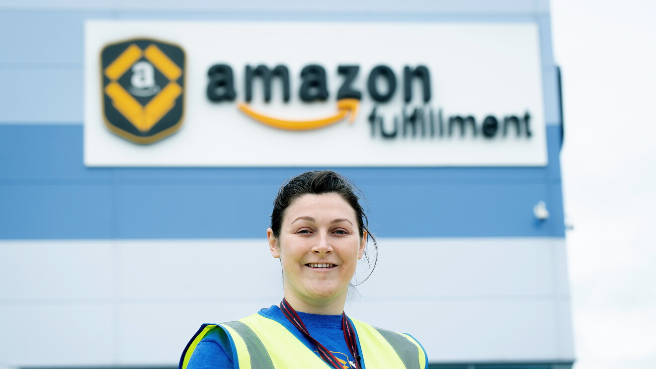 Sophie Martin smiling with a high visibility vest on, outside an Amazon fulfilment centre