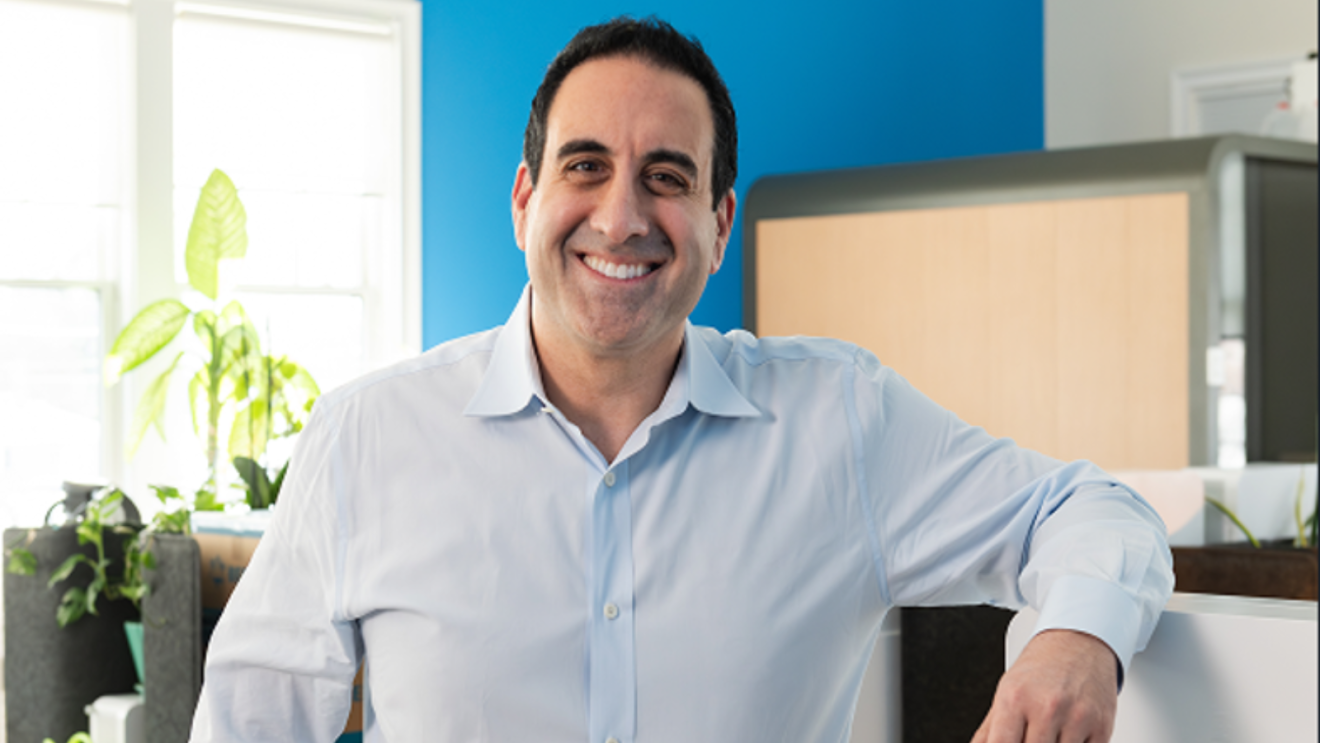Man in light blue shirt smiling in modern office