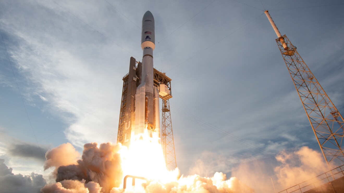 Rocket launching from pad, emitting bright flames and smoke