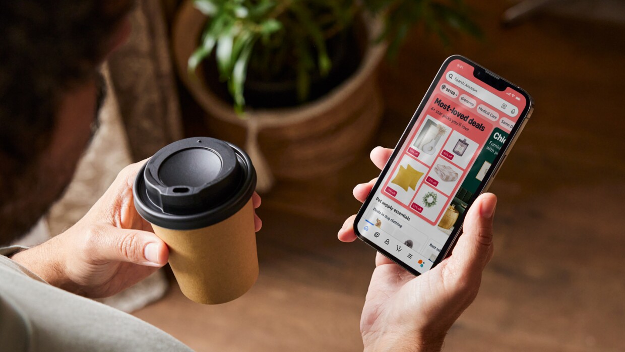 Top view of person holding coffee and a phone with the new window display