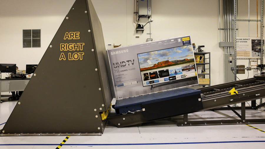 An animated GIF showing a large TV box sliding down a ramp to hit a large, gray wedge. The wedge has the words "Are Right A Lot" painted on it.