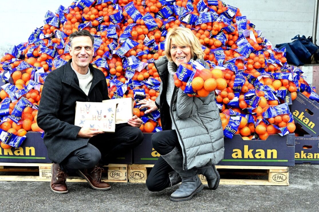 Rocco Bräuniger, Country Manager Amazon.de mit einer Mitarbeiterin vor der Zitrusspende bei der Münchner Tafel.