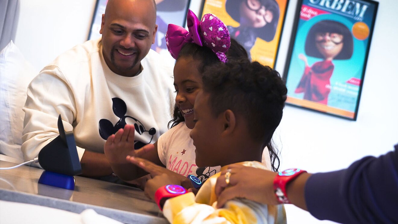 A picture of two kids interacting with an Echo smart speaker with Hey Disney! feature. 