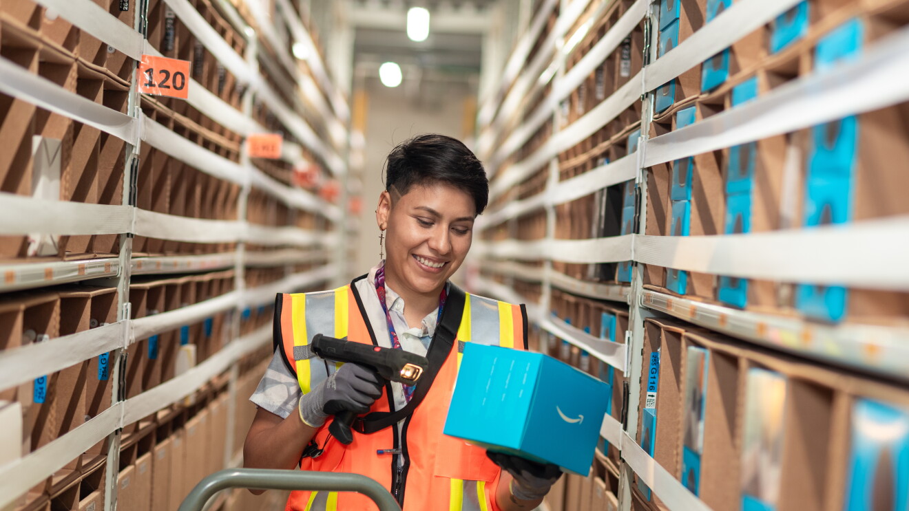 Trabajdora de un centro logístico de Amazon escaneando un producto. 