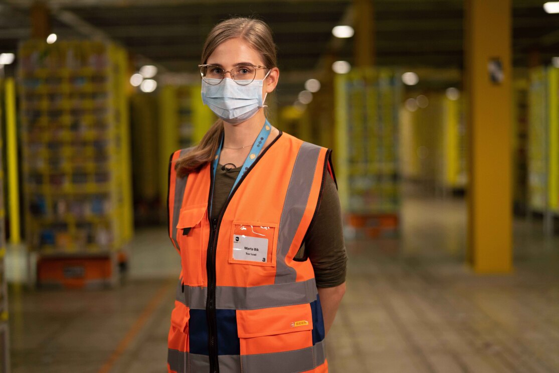 Amazon employee wearing orange high res vest and looking directly at the camera 