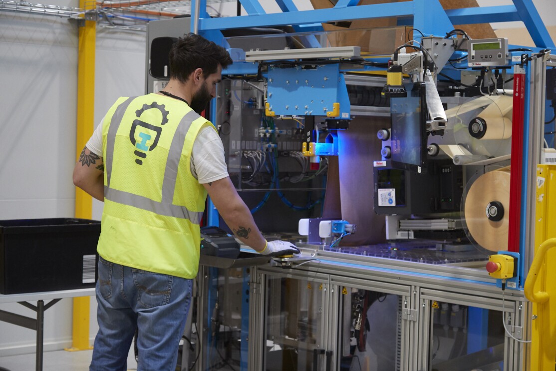 A seasoned employee demonstrates how the automated packaging technology works.