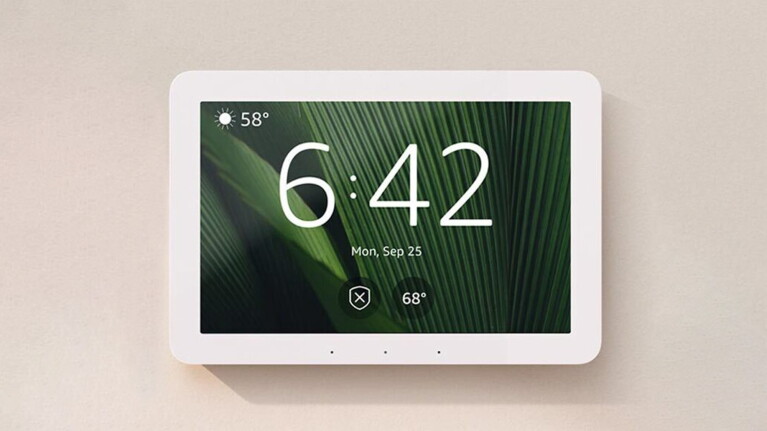 An image of an Echo Hub mounted on a wall showing the home screen.