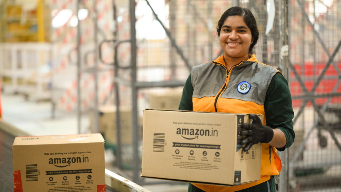 Amazon delivery associate smiling while holding packages