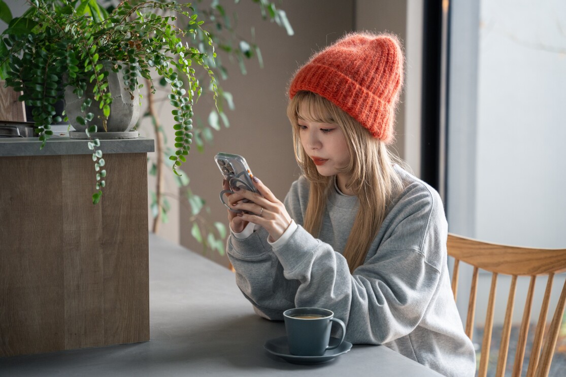 カウンタに座っている赤いニット帽をかぶった女性が携帯を見ている。「さーやんさん」