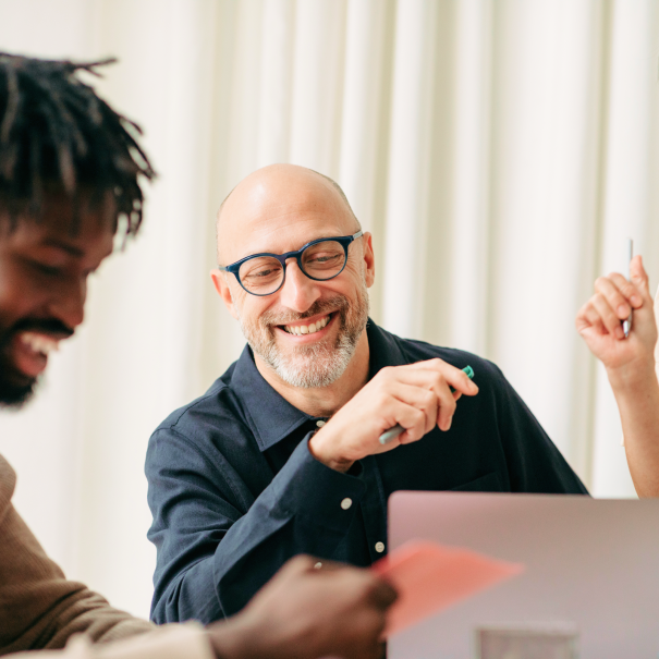 Three people working at a table together collaboratively.