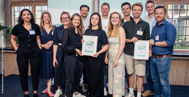 Viele Menschen stehen auf der Bühne der digital.engagiert-Abschluss-veranstaltung. Die Sieger:innen präsentieren ihre Urkunden.